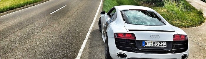 białe audi zaparkowane na poboczu drogi